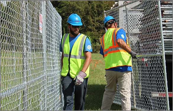 Workers installing temporary fence